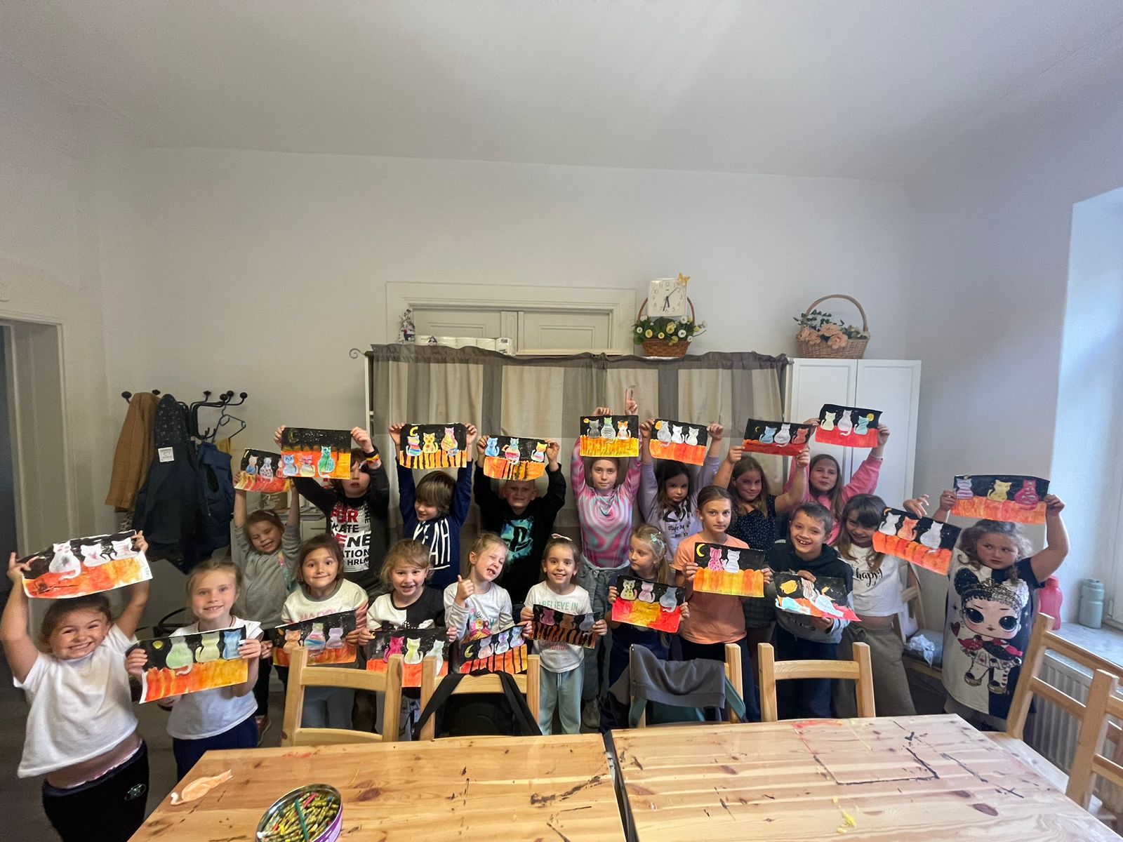 Kinder zeigen ihre gemalten Bilder im Verein